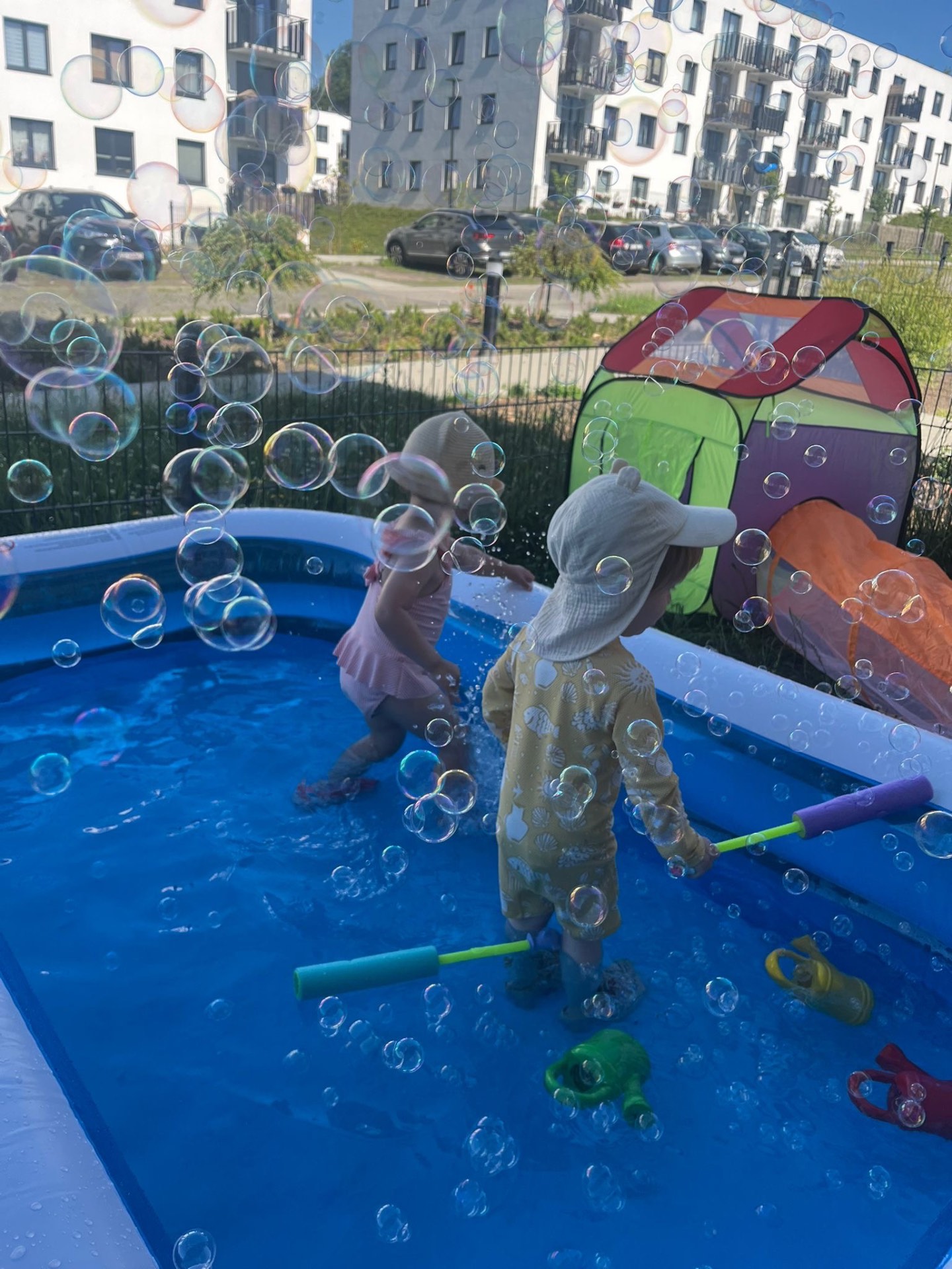 Dzieci bawią się bańkami mydlanymi przy basenie