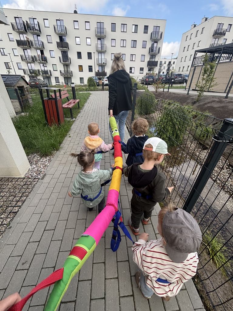 Grupka dzieci na spacerze z kolorową gąsienicą